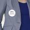 Une personne porte un badge nominatif où est inscrit 'B. Carlos, Directeur marketing' sur un blazer gris par-dessus une chemise bleue.