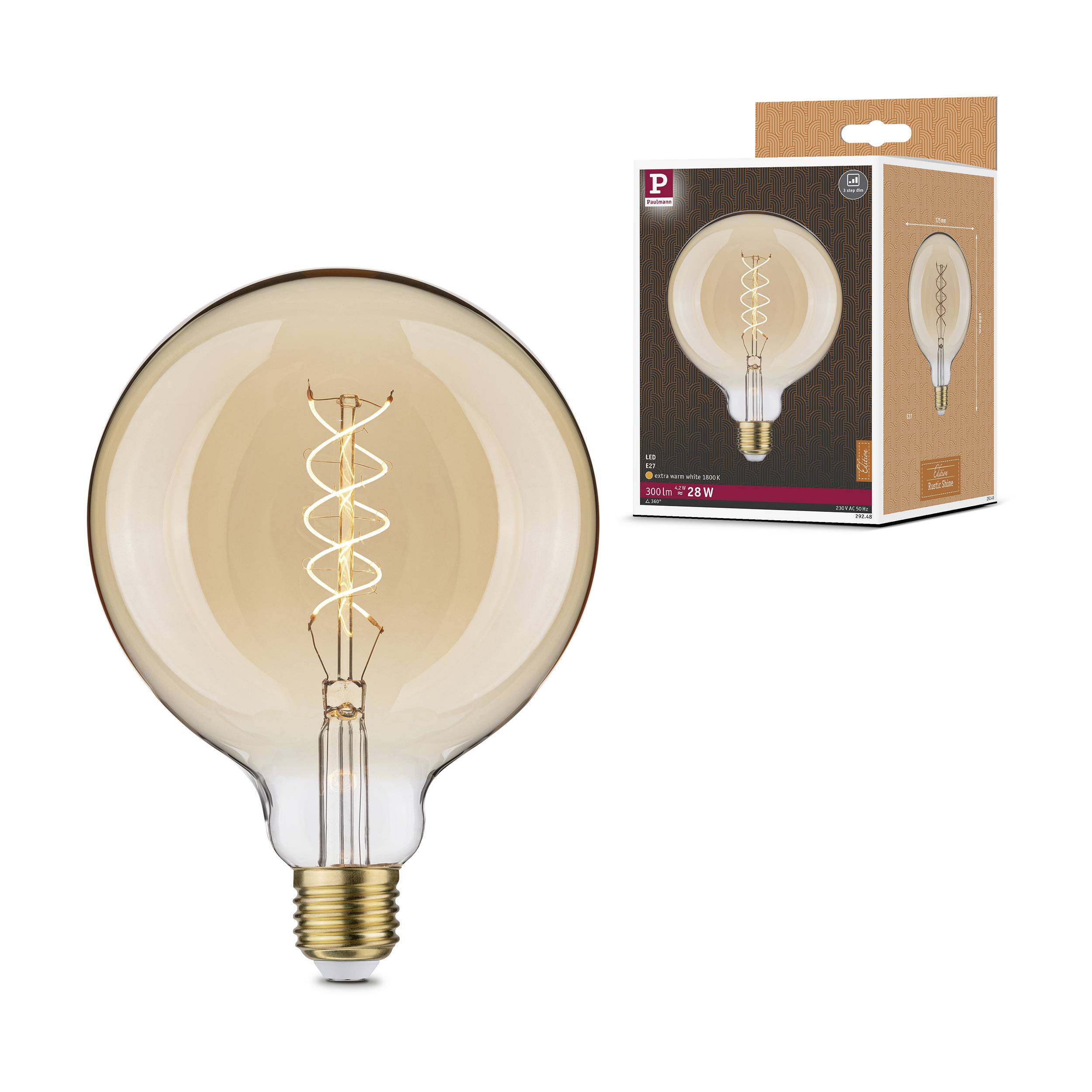 Une grande ampoule transparente avec un filament spiralé visible, posée à côté de son emballage qui présente le même design.