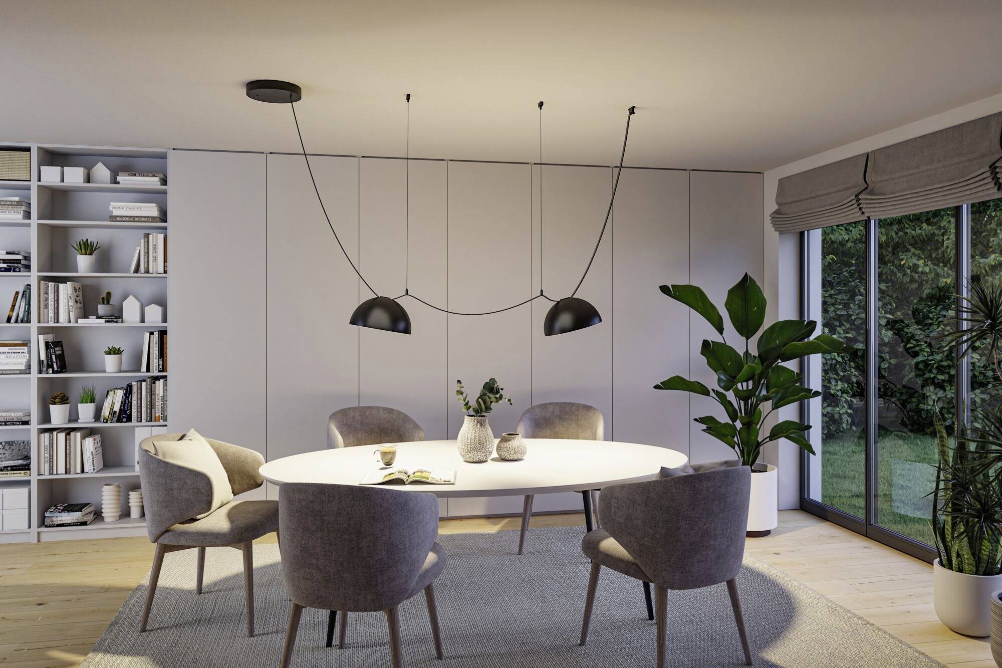 Espace salle à manger moderne avec une table ovale, quatre chaises rembourrées grises et deux suspensions noires. De grandes fenêtres offrent une vue sur le jardin.