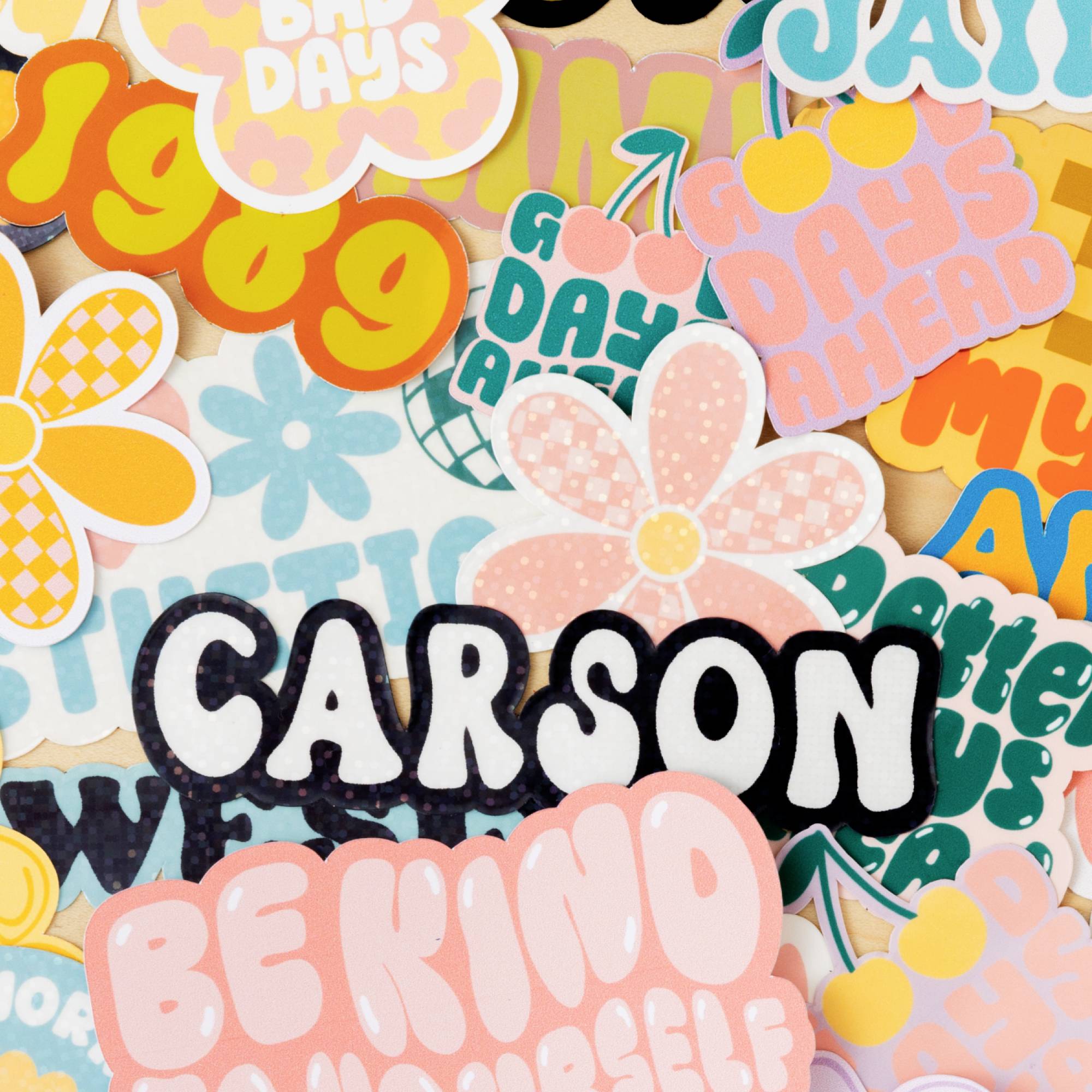 Collage colorée composée d'autocollants et de lettres avec des fleurs et des messages positifs comme 'Sois gentil' et 'Les jours à venir'.