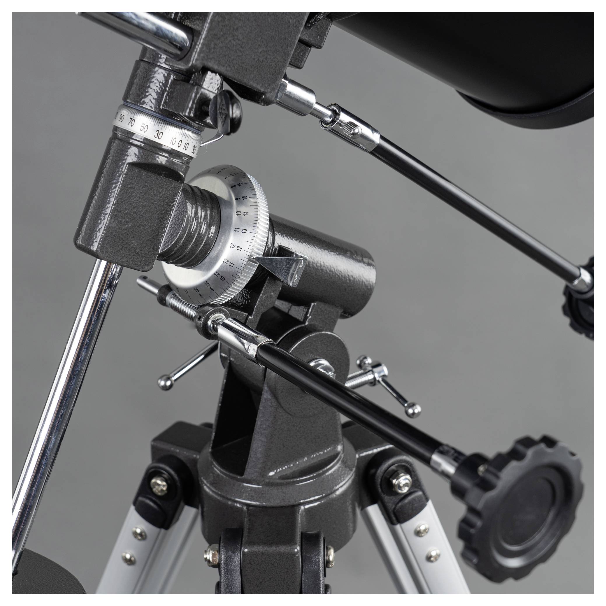 Un trépied de télescope avec un focus sur les pièces métalliques ajustables et les boutons de réglage utilisés pour l'alignement.