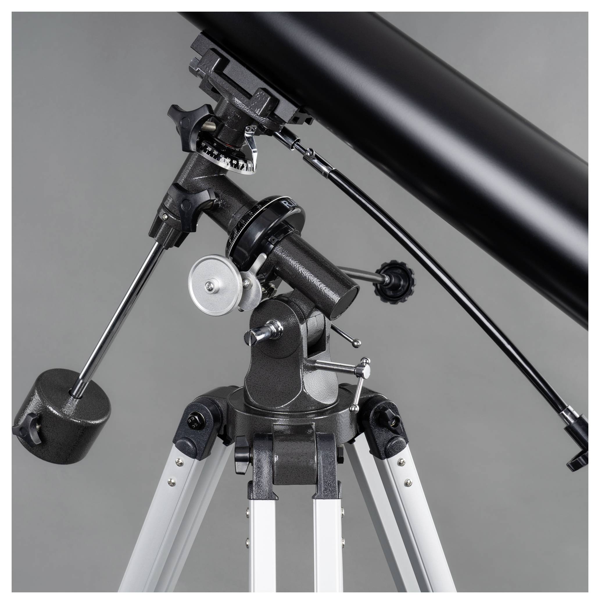 Un télescope noir sur un trépied avec plusieurs mécanismes de réglage, adapté aux observations astronomiques.