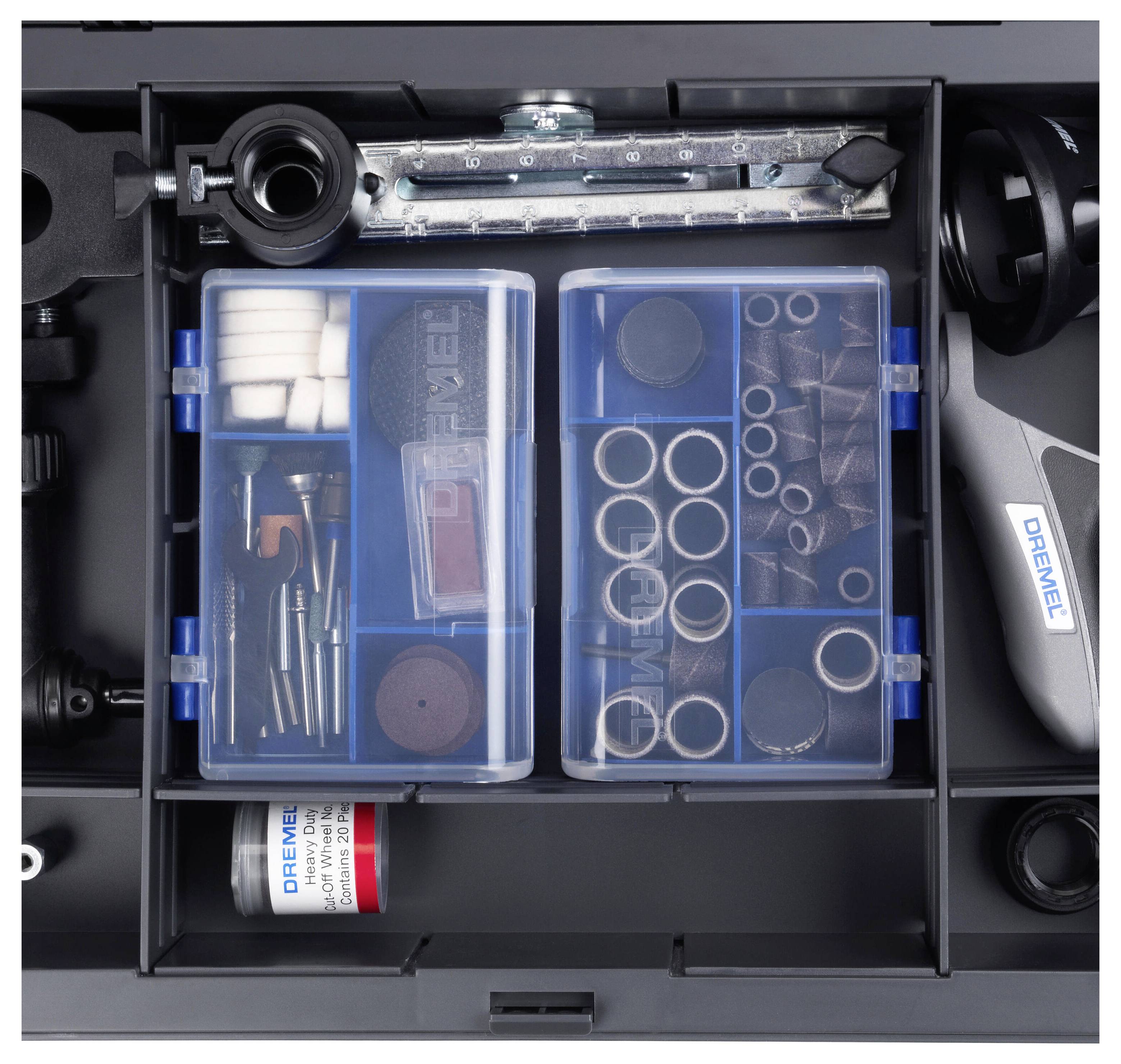 Boîte à outils ouverte contenant divers accessoires Dremel, dont des disques de polissage et de ponçage, des fraises et des embouts rangés dans des compartiments.