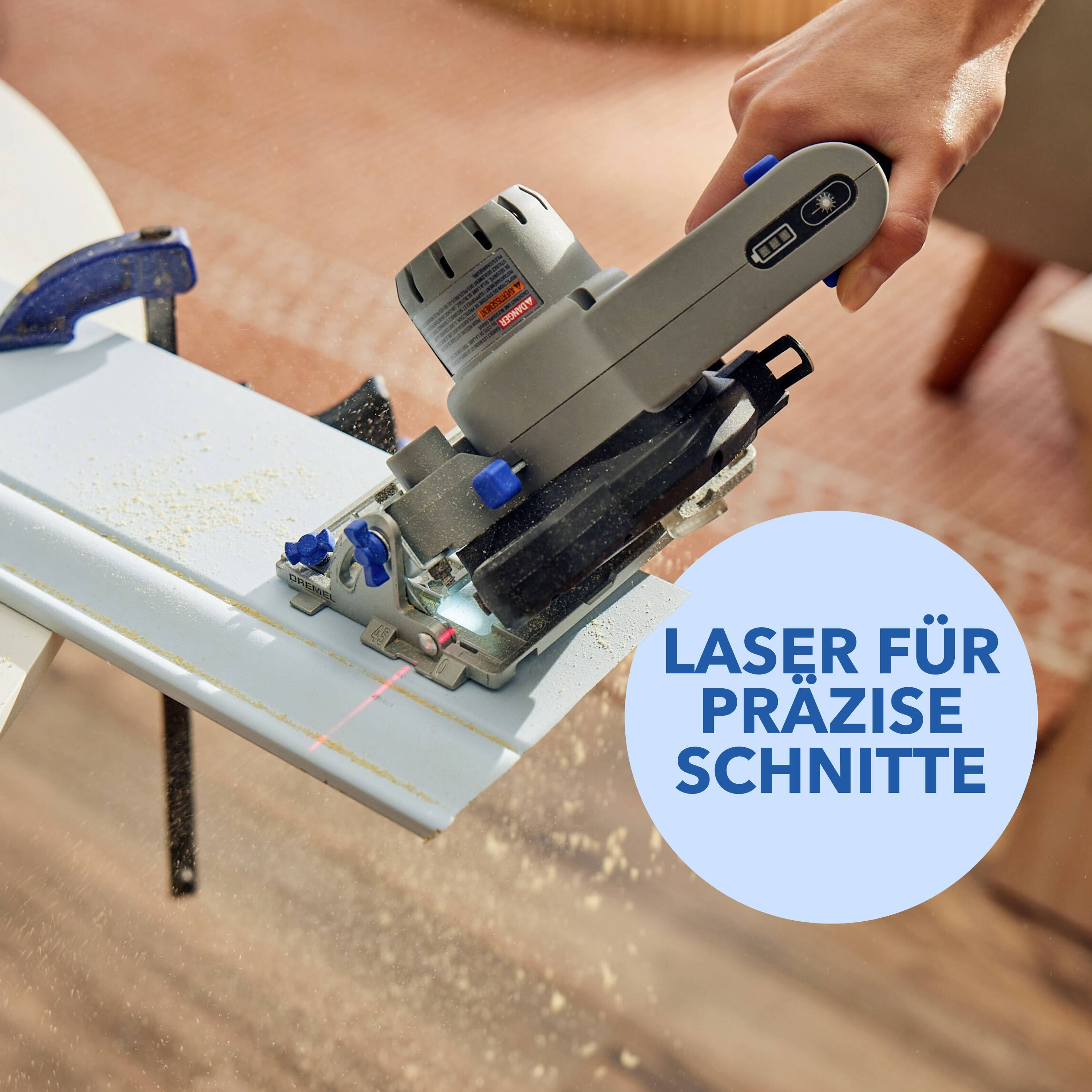 Une main guide une scie électrique le long d'une table bleue. Un rayon laser marque des coupes précises.