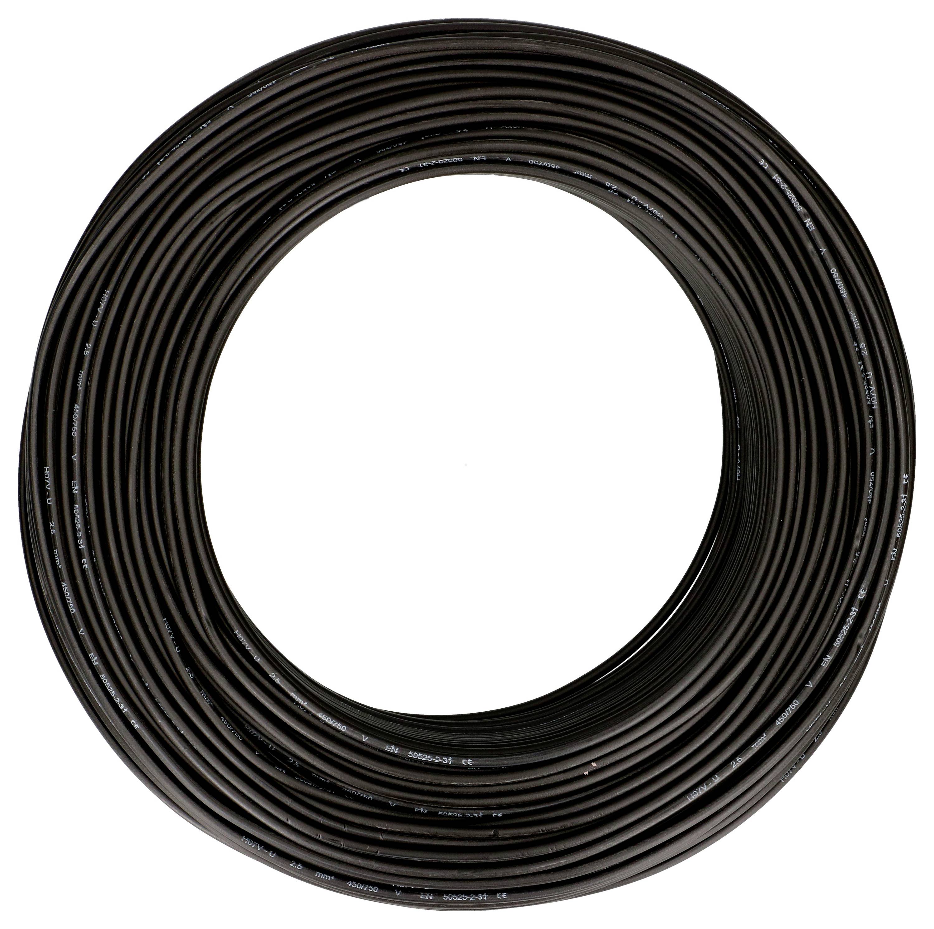 Un grand tambour de câble noir enroulé est posé sur un fond blanc.