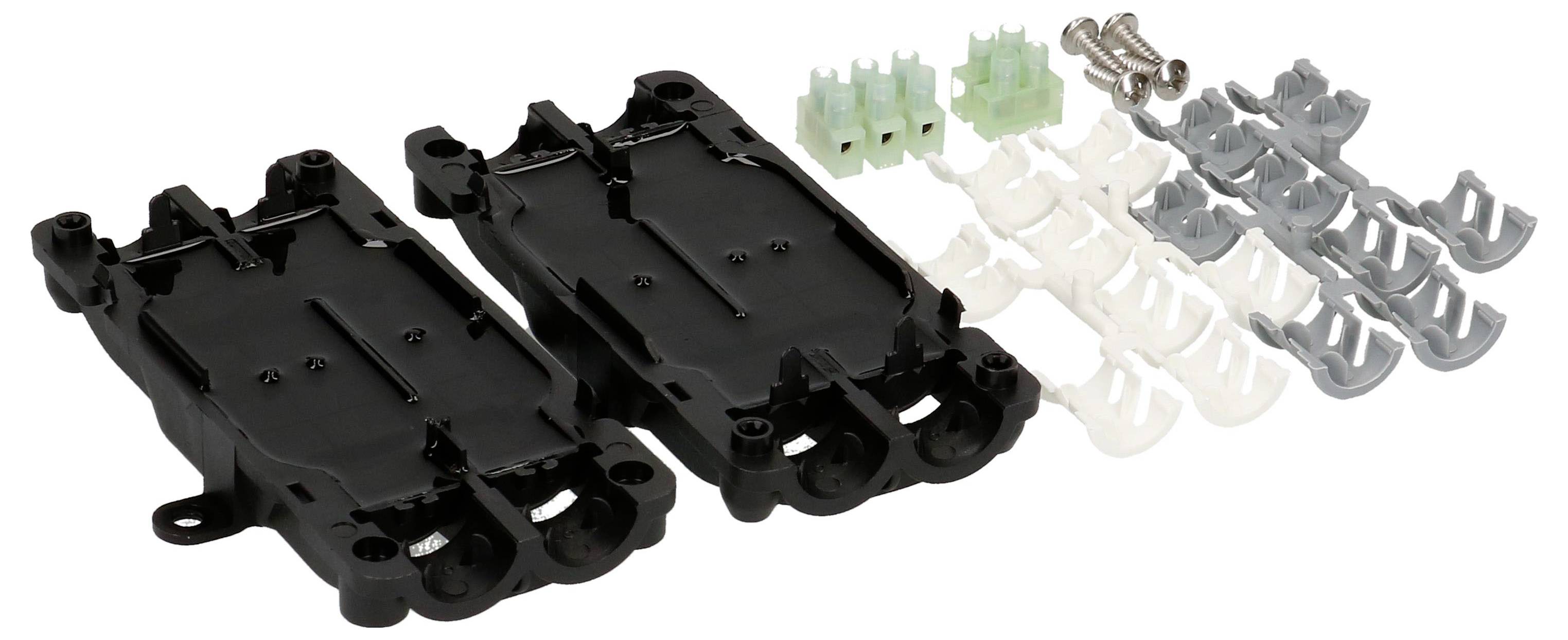 Composants en plastique noir avec des connecteurs verts et des vis argentées, disposés côte à côte sur un fond blanc.