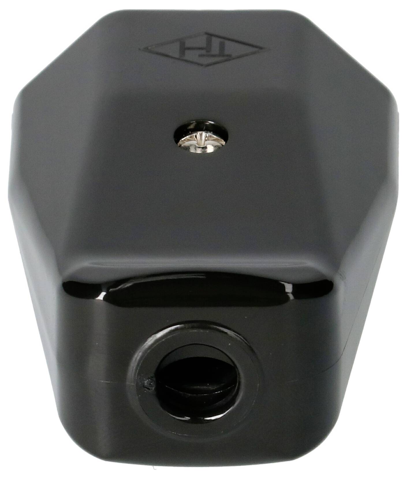 Un appareil noir hexagonal avec une ouverture sur la face avant, probablement destinée à des connexions, et un petit bouton central en haut.