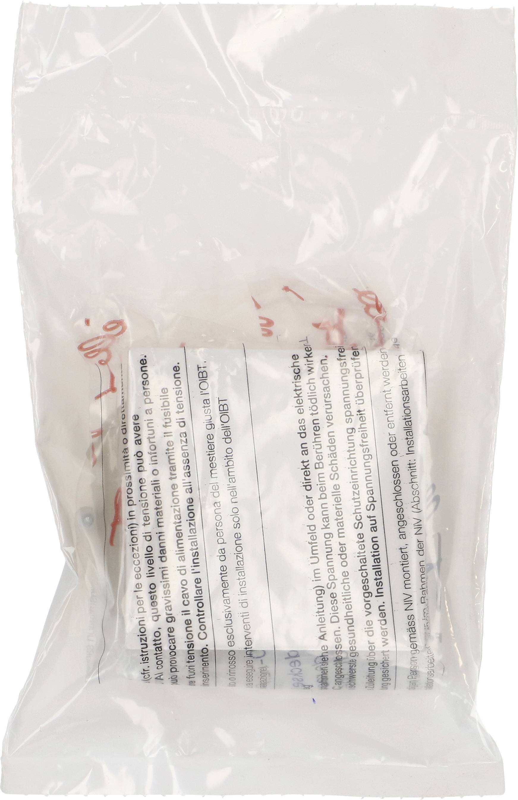 Un sac en plastique transparent contient un emballage blanc avec une inscription multilingue. Le texte est difficile à lire.