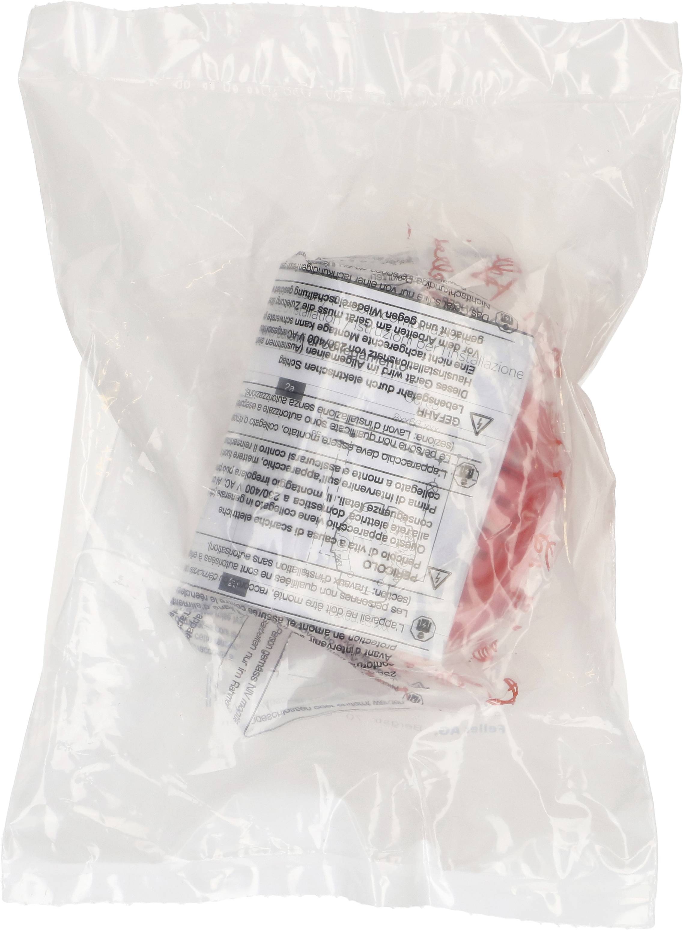 Un sachet en plastique fermé contenant un objet noir et blanc portant une inscription et un élément rouge à l'intérieur.