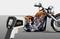 Une personne mesure la température d'une moto orange à l'aide d'un thermomètre sans contact. Un point laser rouge indique l'emplacement de la mesure.