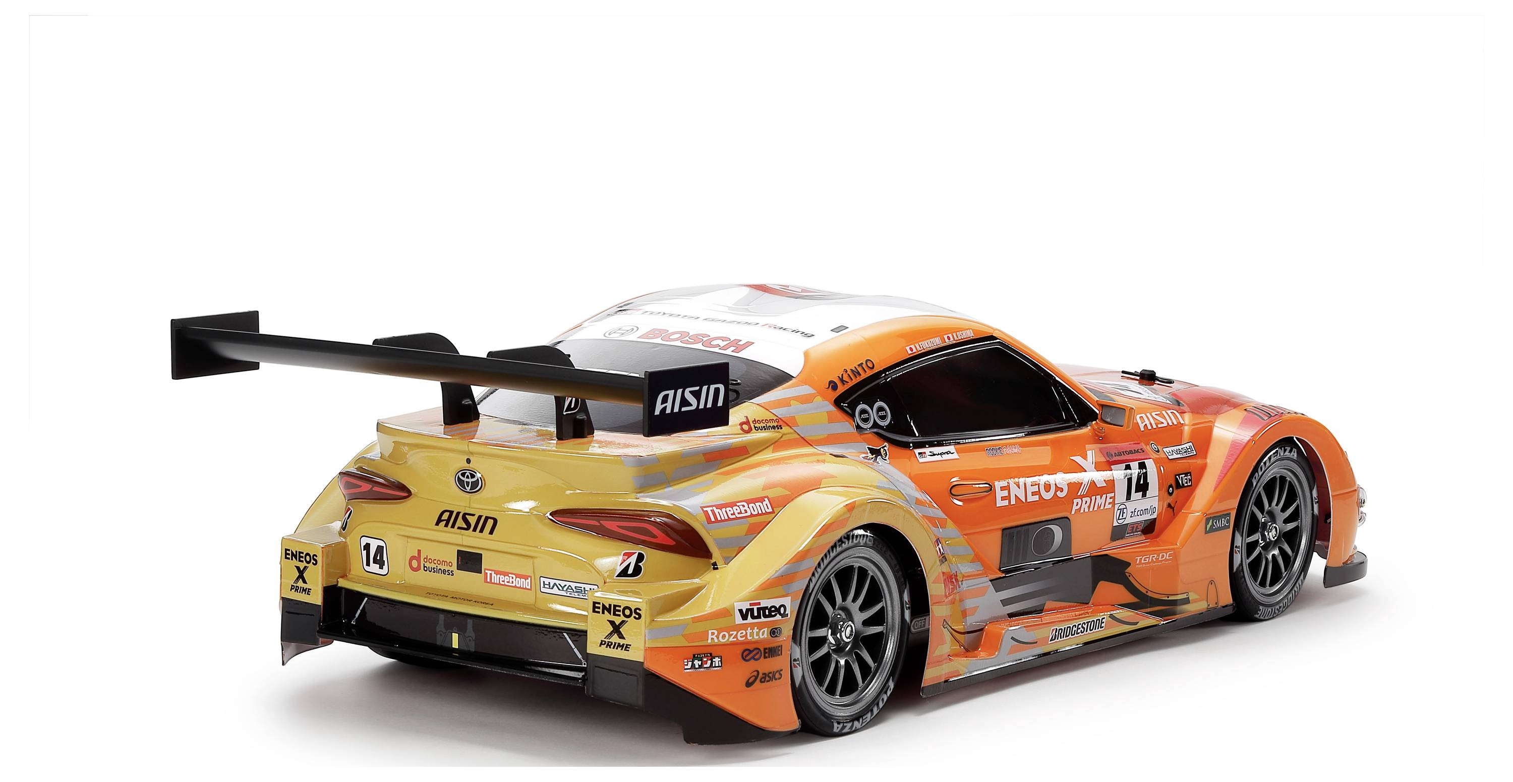 Une voiture de course orange avec des logos de sponsors voyants et un grand aileron arrière, photographiée de dos dans un contexte de course.