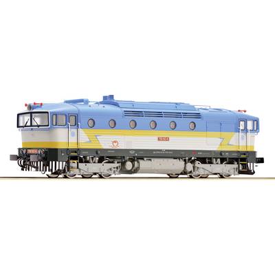 Un train miniature avec une peinture bleue et jaune est posé sur une voie. Le train a un avant arrondi et plusieurs fenêtres rondes.