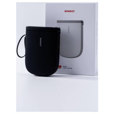 Un imprimante d'étiquettes noir de NIIMBOT est placé devant son emballage. Sur l'emballage, on peut lire « NIIMBOT Smart Label Printer ».