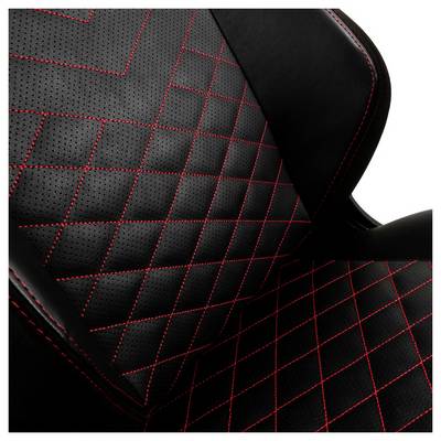 Gros plan sur un siège de chaise noir rembourré avec un motif de losanges rouges diagonaux.