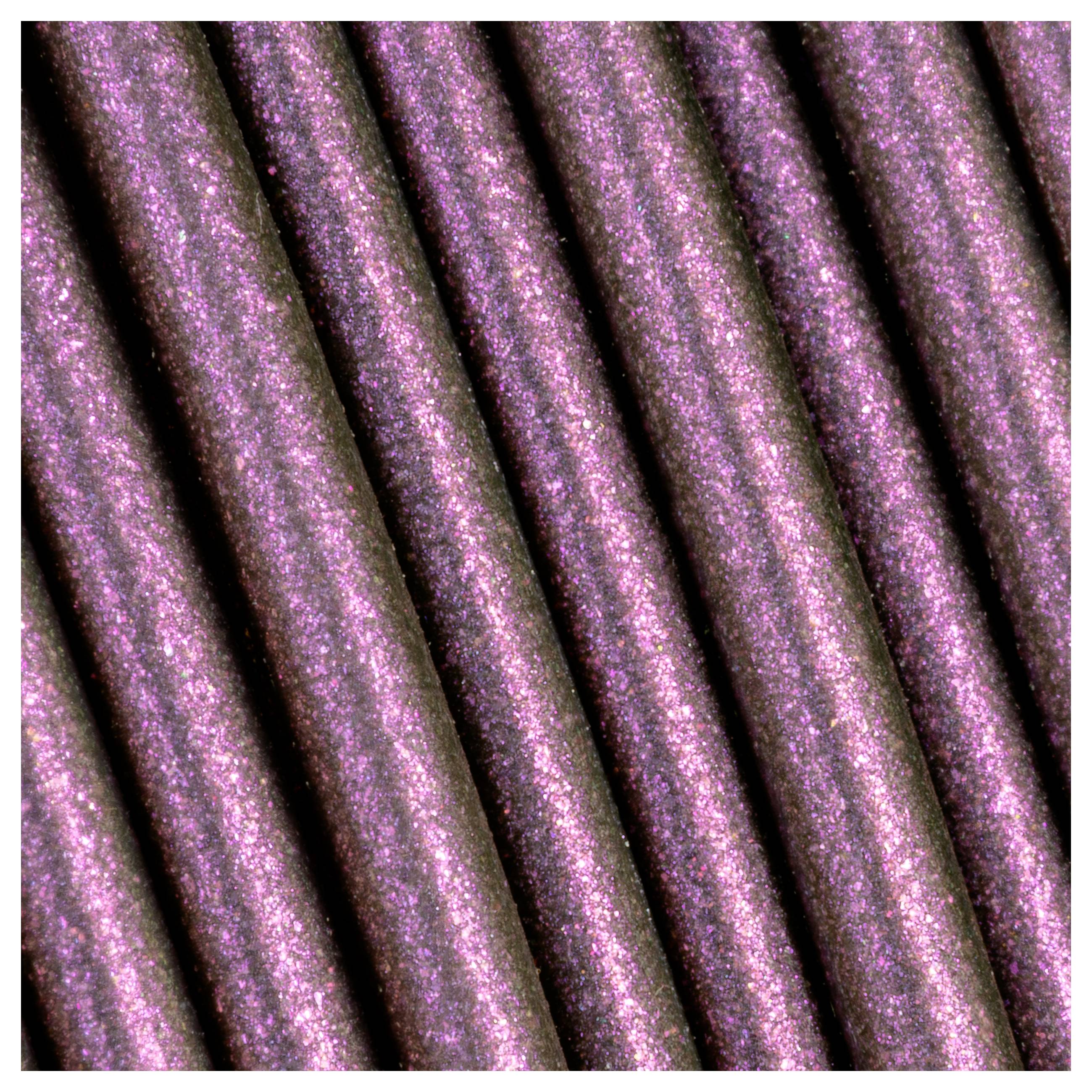 Gros plan d'un tissu rose brillant avec des lignes de texture diagonales qui s'étendent sur l'image.