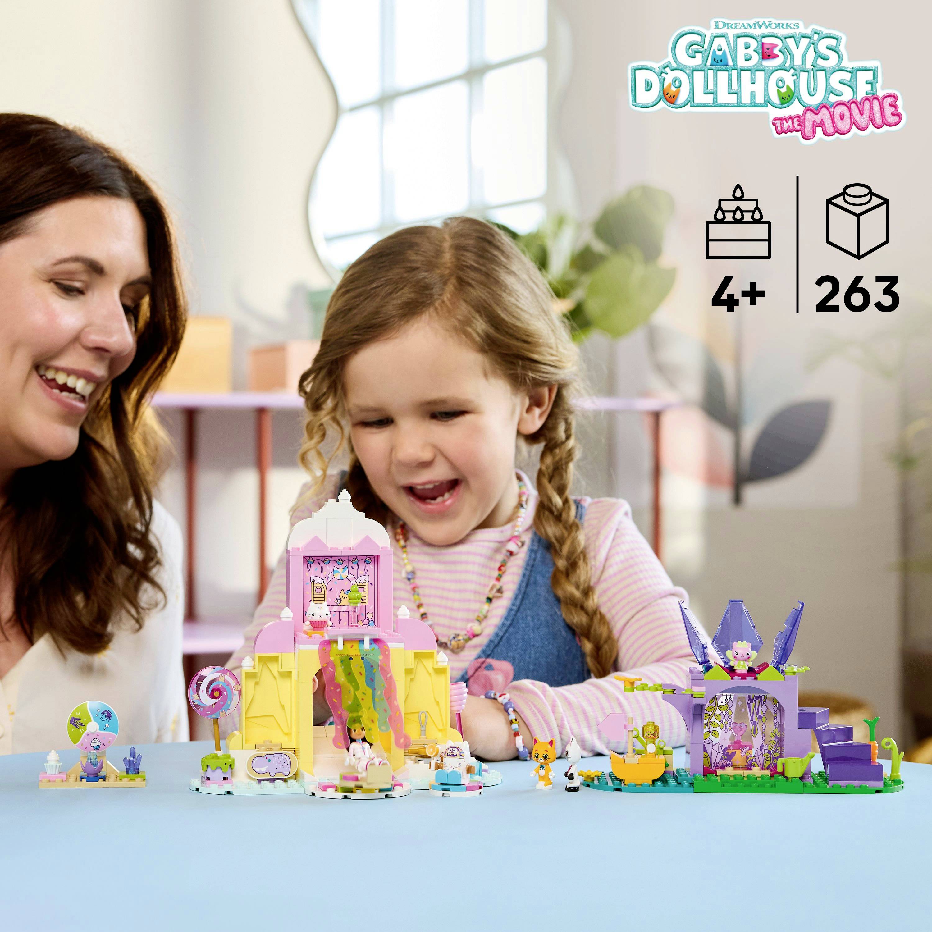 Une femme et une jeune fille sourient tout en jouant avec des ensembles de jouets colorés de « La Maison des Poupées de Gabby : Le Film ». Le logo et la tranche d'âge 4+ sont visibles.