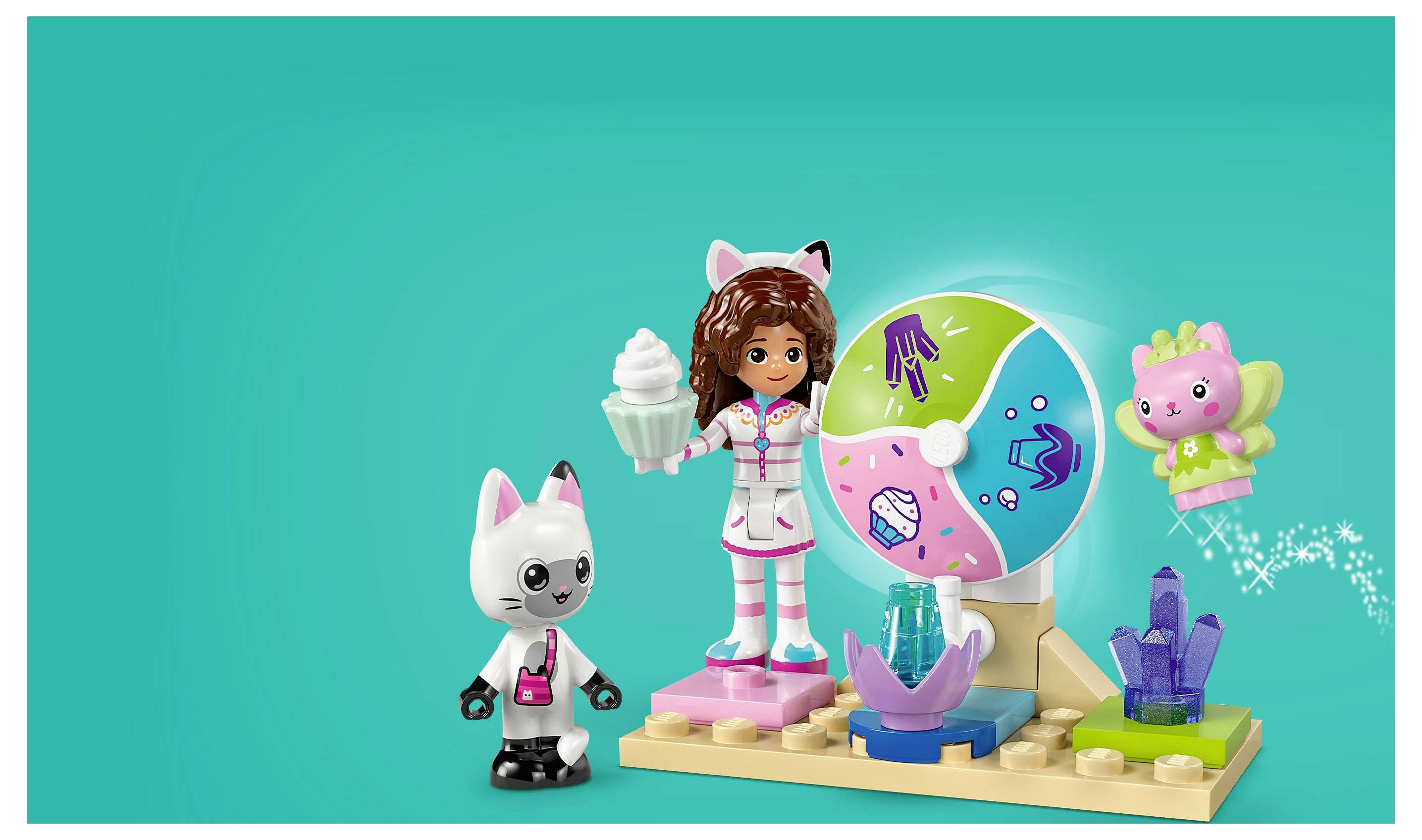 Un ensemble de jouets présentant une figurine de fille portant un costume à thème animal, tenant une boisson, accompagnée d'une figurine de chat et d'une sphère colorée avec des accessoires sur un socle d'exposition.