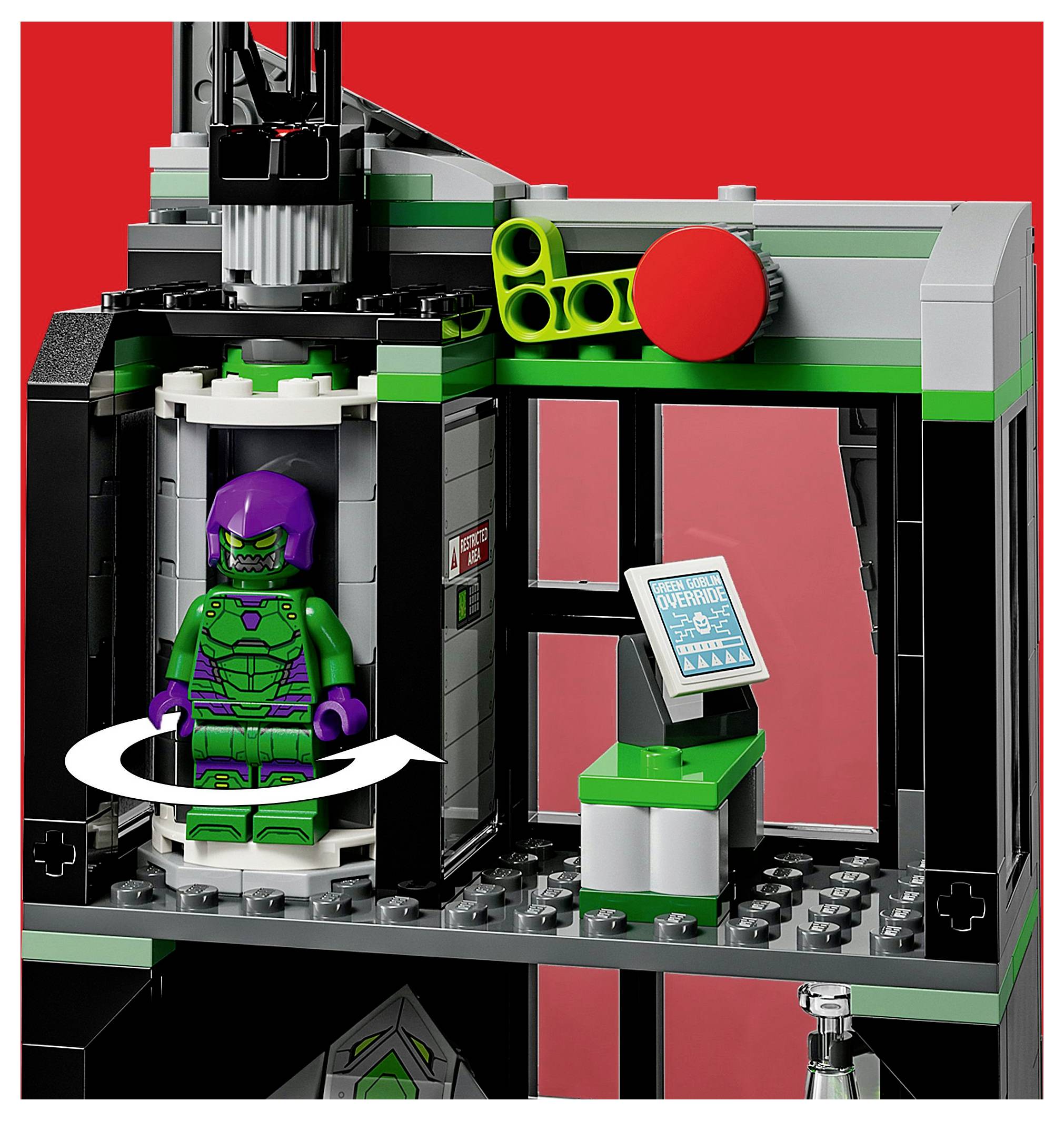 Une scène LEGO montrant une figurine de méchant à l'intérieur d'une chambre rotative, avec un panneau de contrôle à proximité. L'arrière-plan est rouge vif.