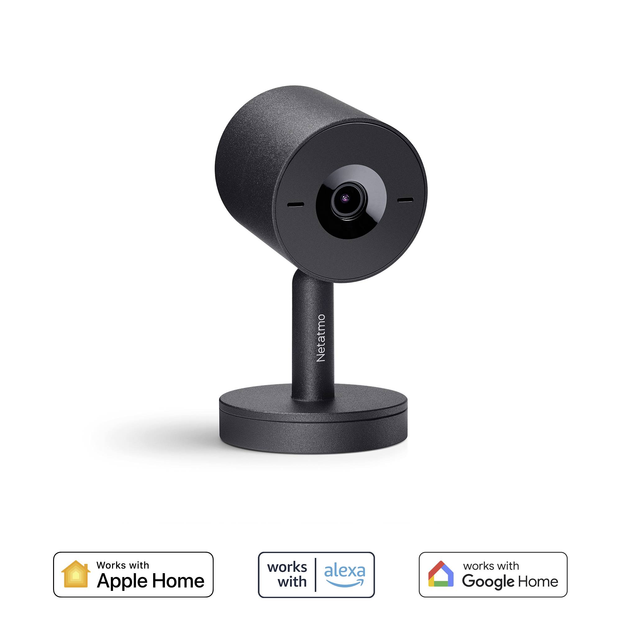 Une caméra de surveillance noire de Netatmo posée sur une table. Les logos indiquent sa compatibilité avec Apple Home, Alexa et Google Home.
