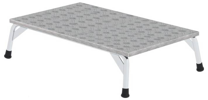 Un podium rectangulaire surélevé en métal avec une surface antidérapante. Il est doté de quatre pieds courts et supports, munis de embouts en caoutchouc noir.