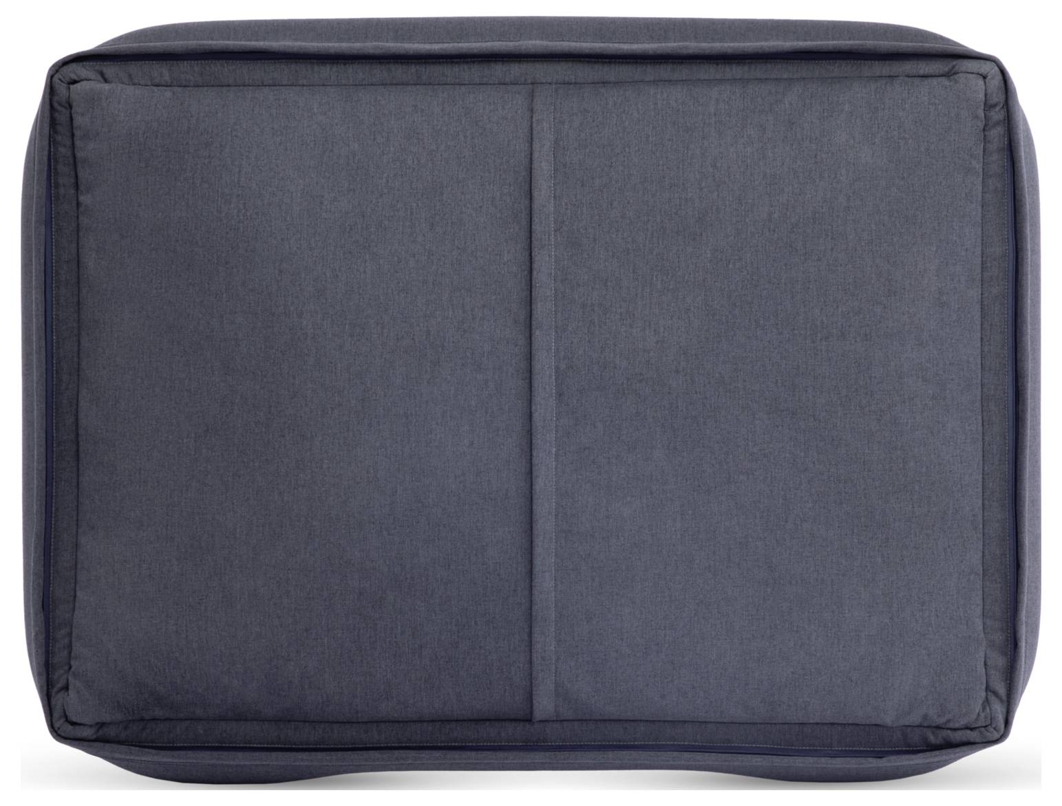 Un coussin gris foncé de forme rectangulaire à surface lisse. Le coussin présente des coins légèrement arrondis et des lignes de couture.
