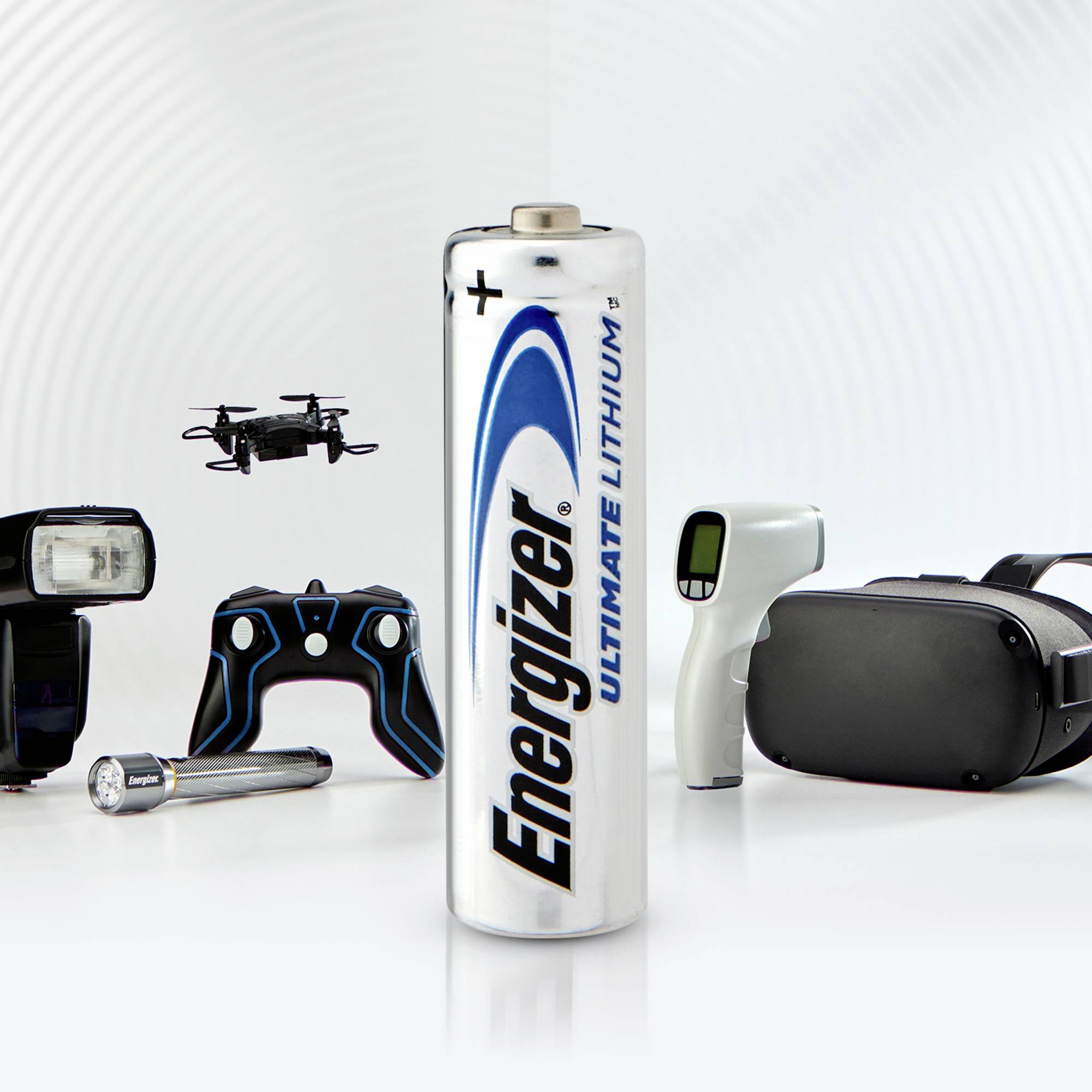 Batterie Lithium Energizer au centre, entourée d'appareils électroniques comme une manette de jeu, des lunettes de réalité virtuelle et un drone.