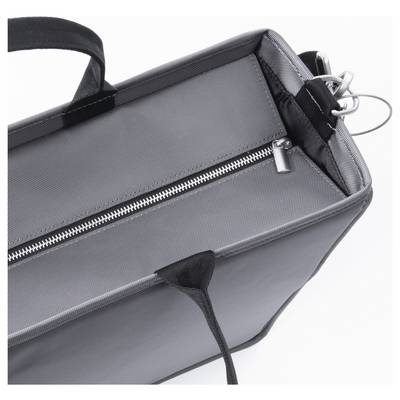 Un sac gris et noir avec une fermeture éclair et deux anses. La vue de dessus montre les coutures et la structure du matériau du sac.