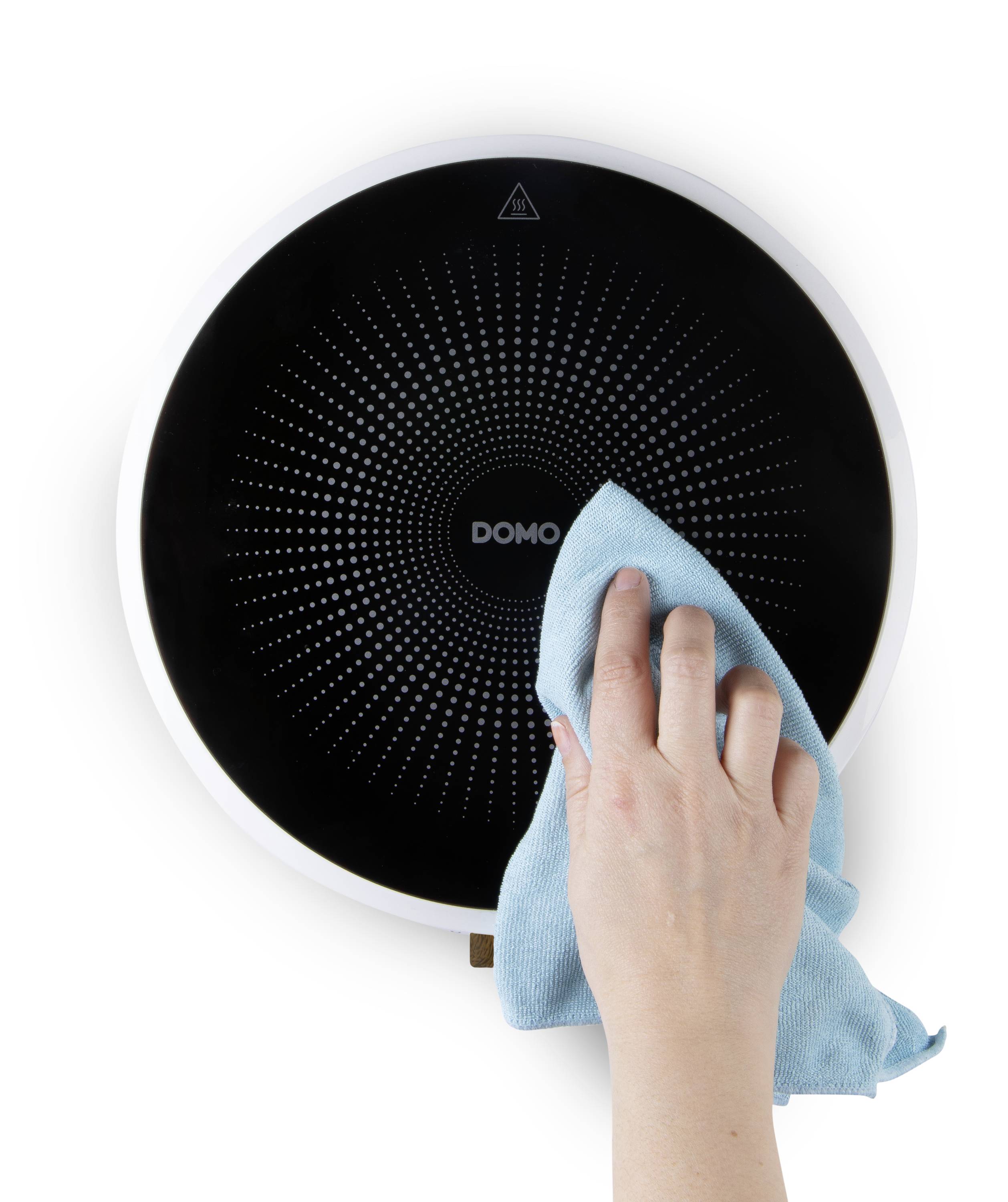 Une main nettoie une surface noire et ronde avec un chiffon bleu. En haut, un symbole triangulaire, au milieu duquel est inscrit 'DOMO'.