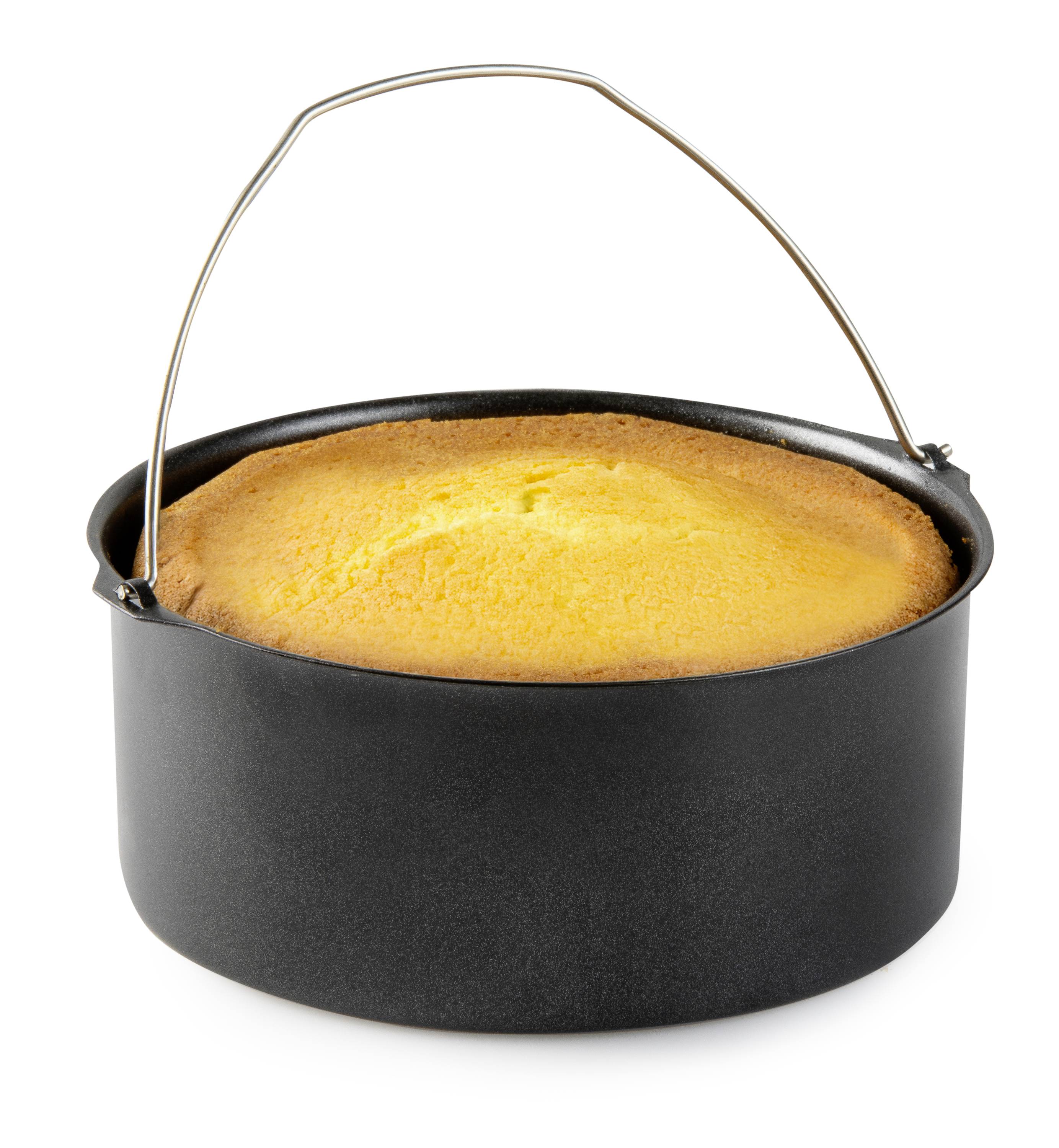 Un gâteau rond, fraîchement sorti du four, dans une casserole noire avec une poignée. Le gâteau est doré et semble moelleux.