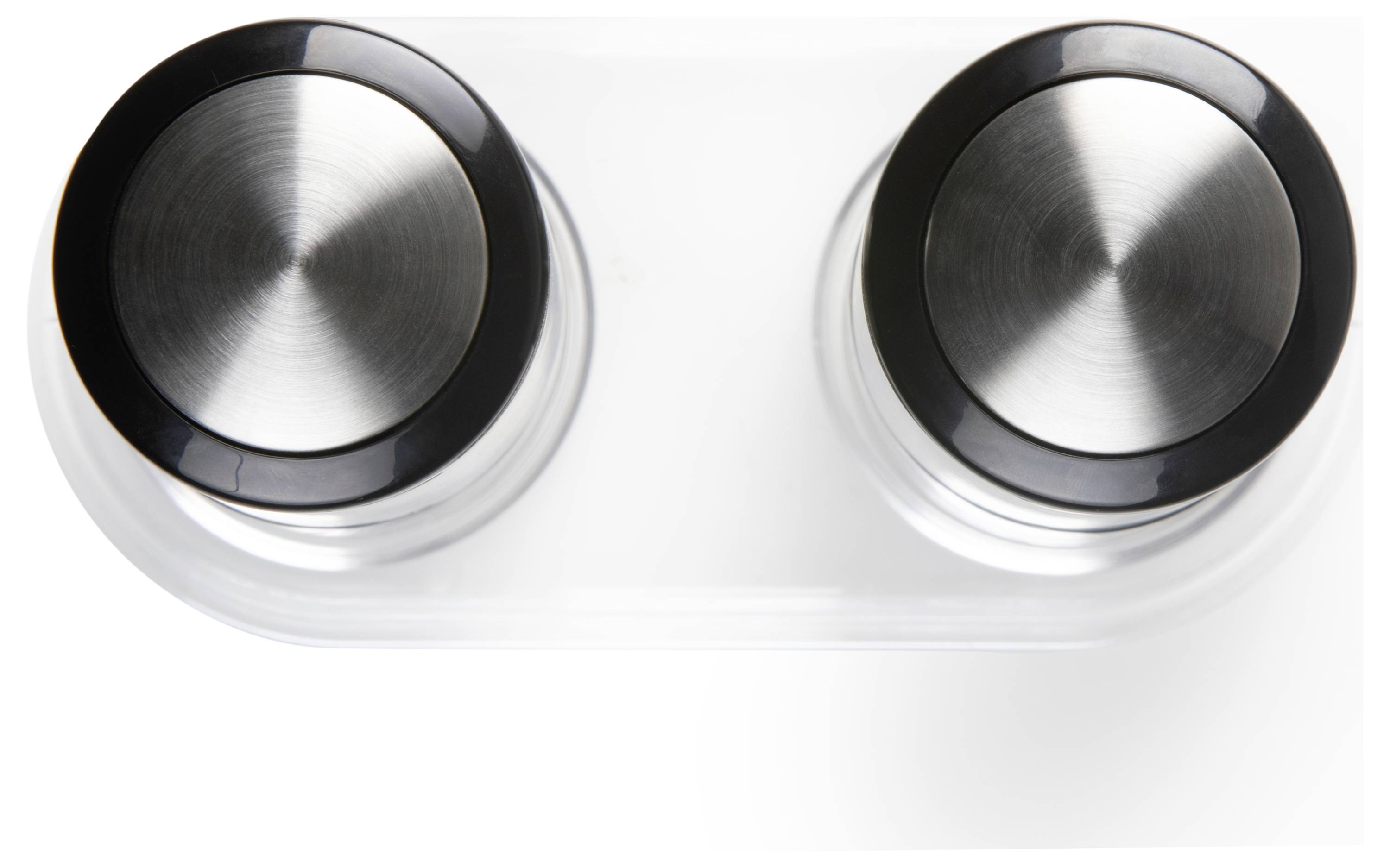Deux boutons de réglage circulaires en métal avec un bord noir sur une base transparente.