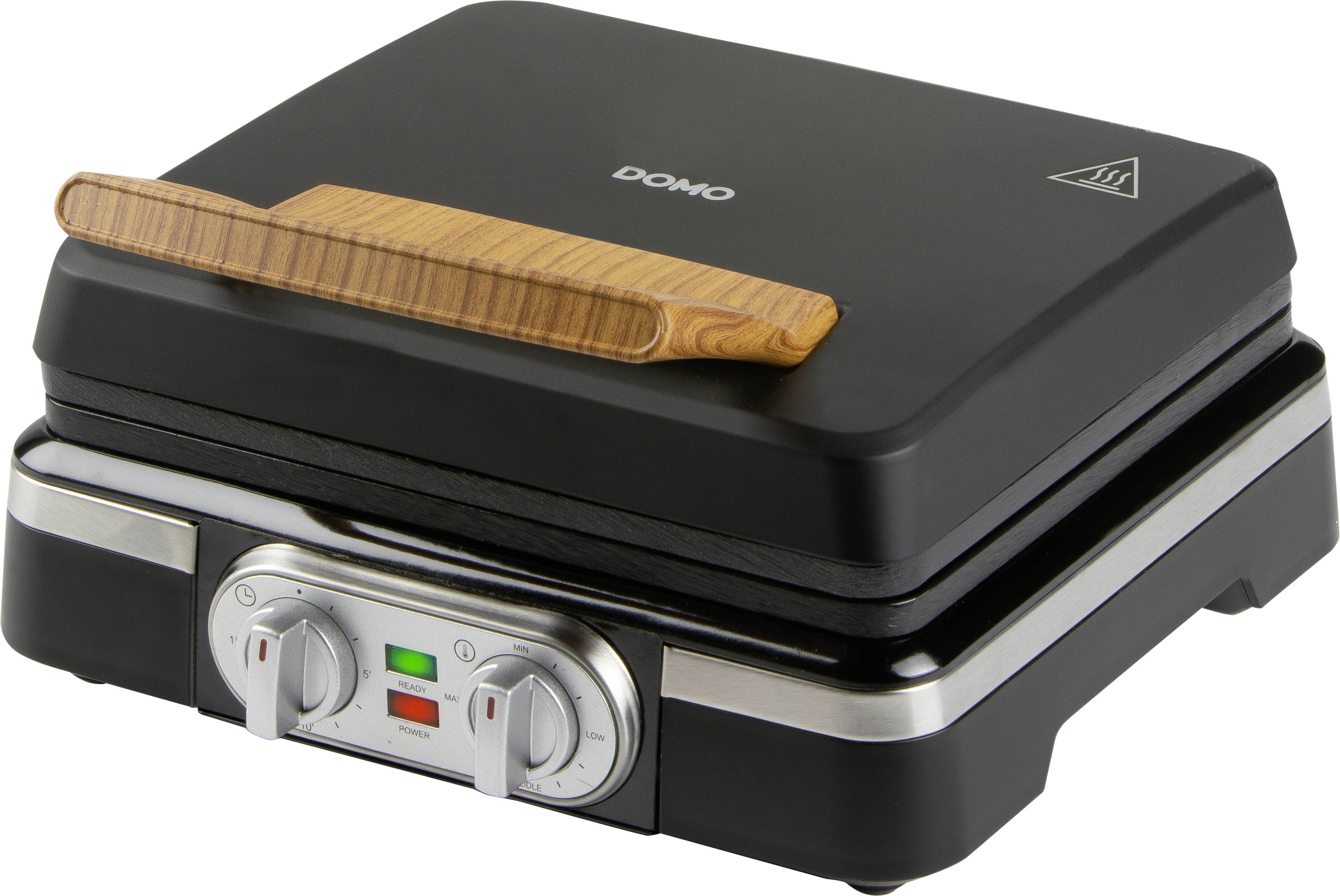 Un grill à panini noir avec poignée en bois, doté d'un régulateur de température et de voyants lumineux. Logo de la marque en haut de l'appareil.