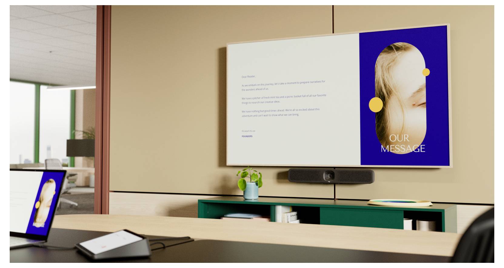 Un espace de bureau moderne avec un mur beige comportant un écran affichant du texte et une image intitulée « Notre Message ». Une table de conférence est au premier plan.