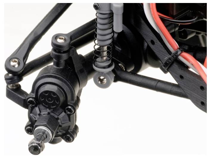 Gros plan sur un système de suspension de voiture télécommandée. On distingue des amortisseurs, des éléments de suspension et une partie du système de suspension de roue.