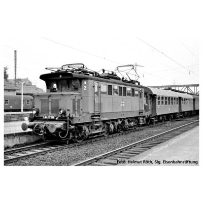 Une locomotive électrique historique E44 avec des voitures de voyageurs attenantes est stationnée sur un quai. La scène montre une installation ferroviaire.