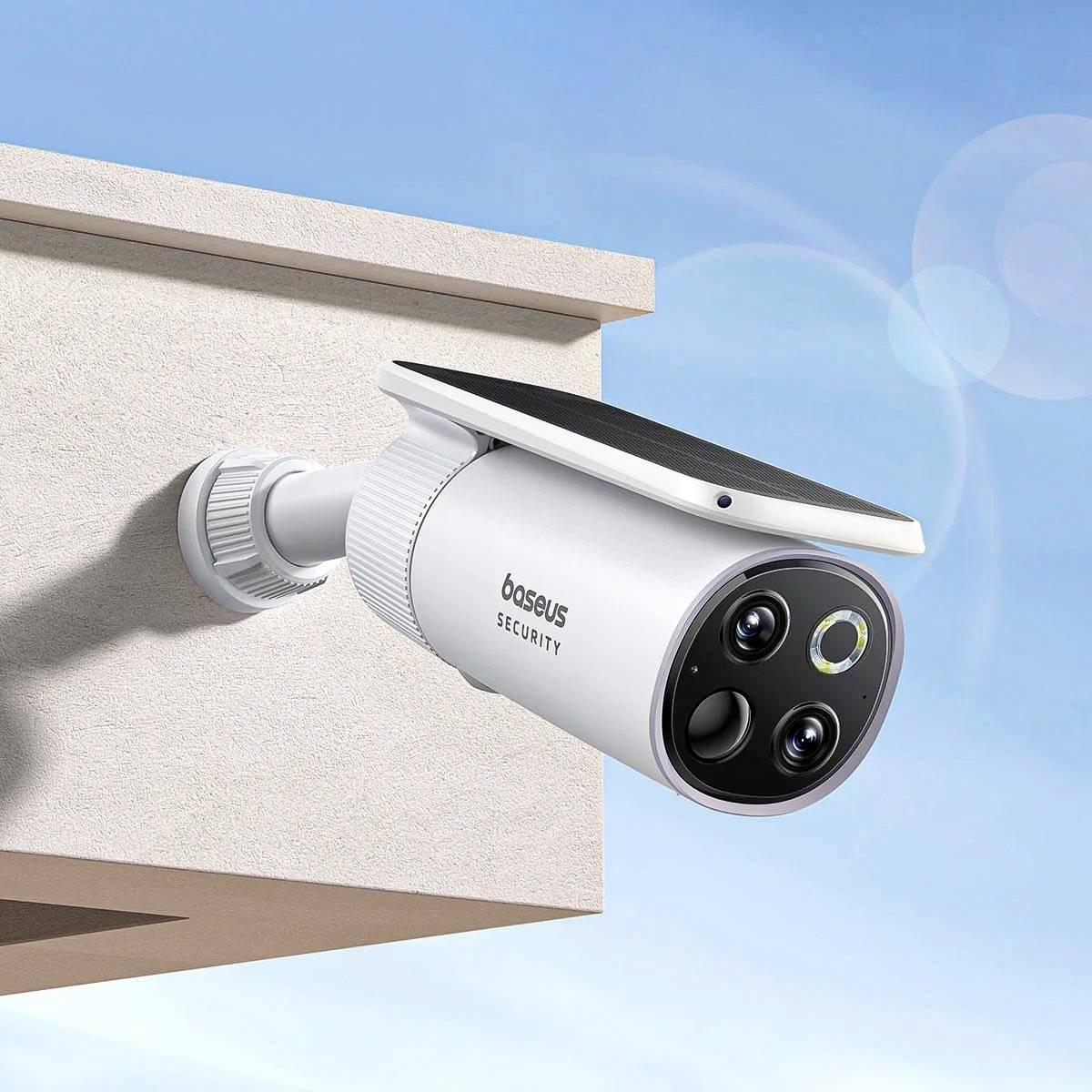 Caméra de surveillance montée sur le mur extérieur d'un bâtiment, orientée vers le bas. Design résistant aux intempéries avec capteur de mouvement intégré.