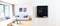 Un salon moderne avec un thermostat numérique au mur affichant 23,2 degrés. Des meubles lumineux et des œuvres d'art en arrière-plan.