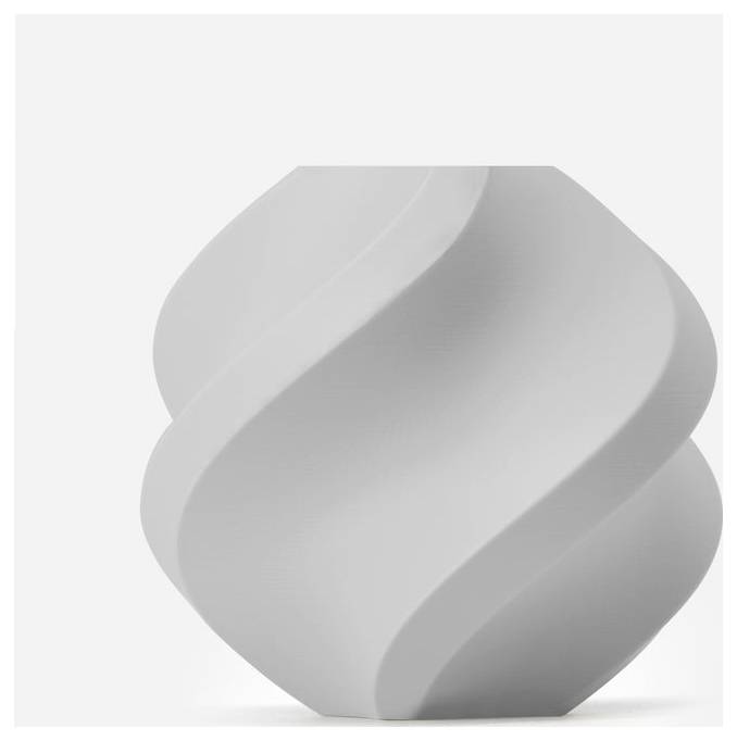 Un vase blanc au design en spirale devant un fond neutre.