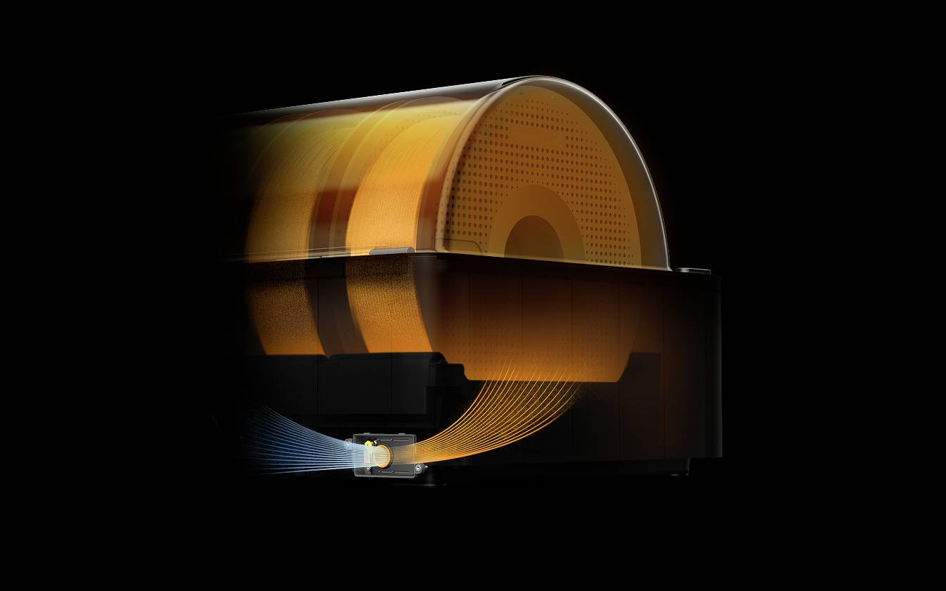 Un appareil transparent révèle des bobines et des câbles orangés aux contours flous sur un fond noir. Les fonctions principales ne sont pas identifiables.