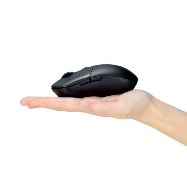 Une main tient une souris d'ordinateur noire, vue de côté sur un fond blanc.