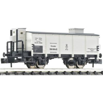 Un wagon de marchandises modèle sur une voie ferrée, peint en blanc, avec une inscription noire 'Dresden 550 954'. Installation de freinage détaillée visible.