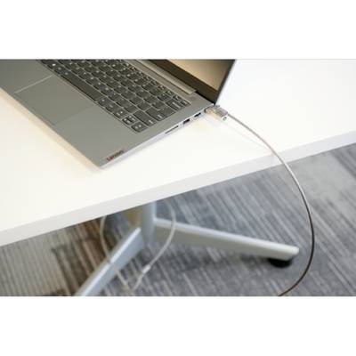 Un ordinateur portable gris est posé sur une table blanche. Un câble de sécurité est fixé sur le côté de l'ordinateur portable et le maintient attaché à la table.