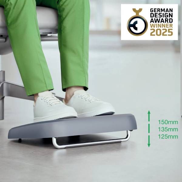 Une personne est assise sur une chaise, portant un pantalon vert et des chaussures blanches, utilisant un repose-pieds réglable en trois hauteurs différentes. Le logo 'German Design Award Winner 2025' est situé en haut à droite.