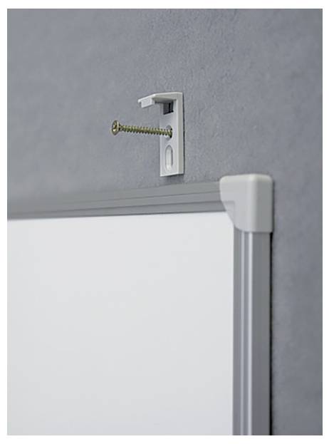 Un tableau blanc est fixé à un mur gris à l'aide d'une vis et d'un crochet.
