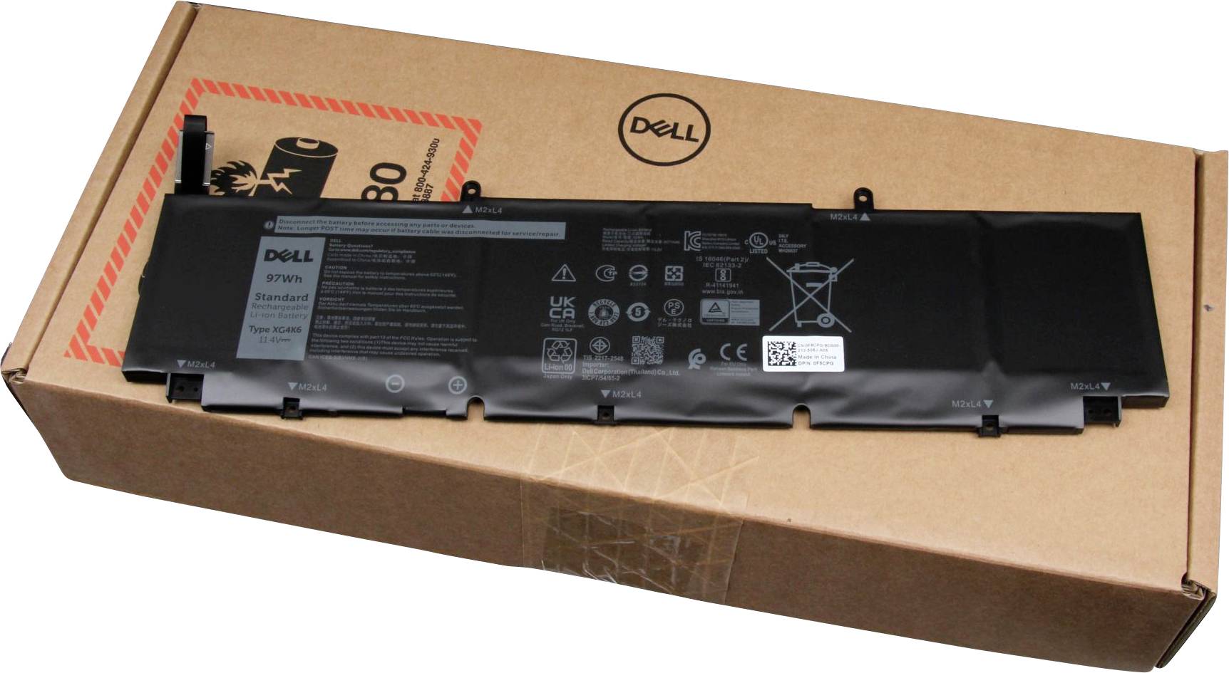 Batterie d'un ordinateur portable Dell sur son emballage. Forme rectangulaire noire avec des indications de performance et des symboles d'avertissement sur le dessus. Emballage en carton.