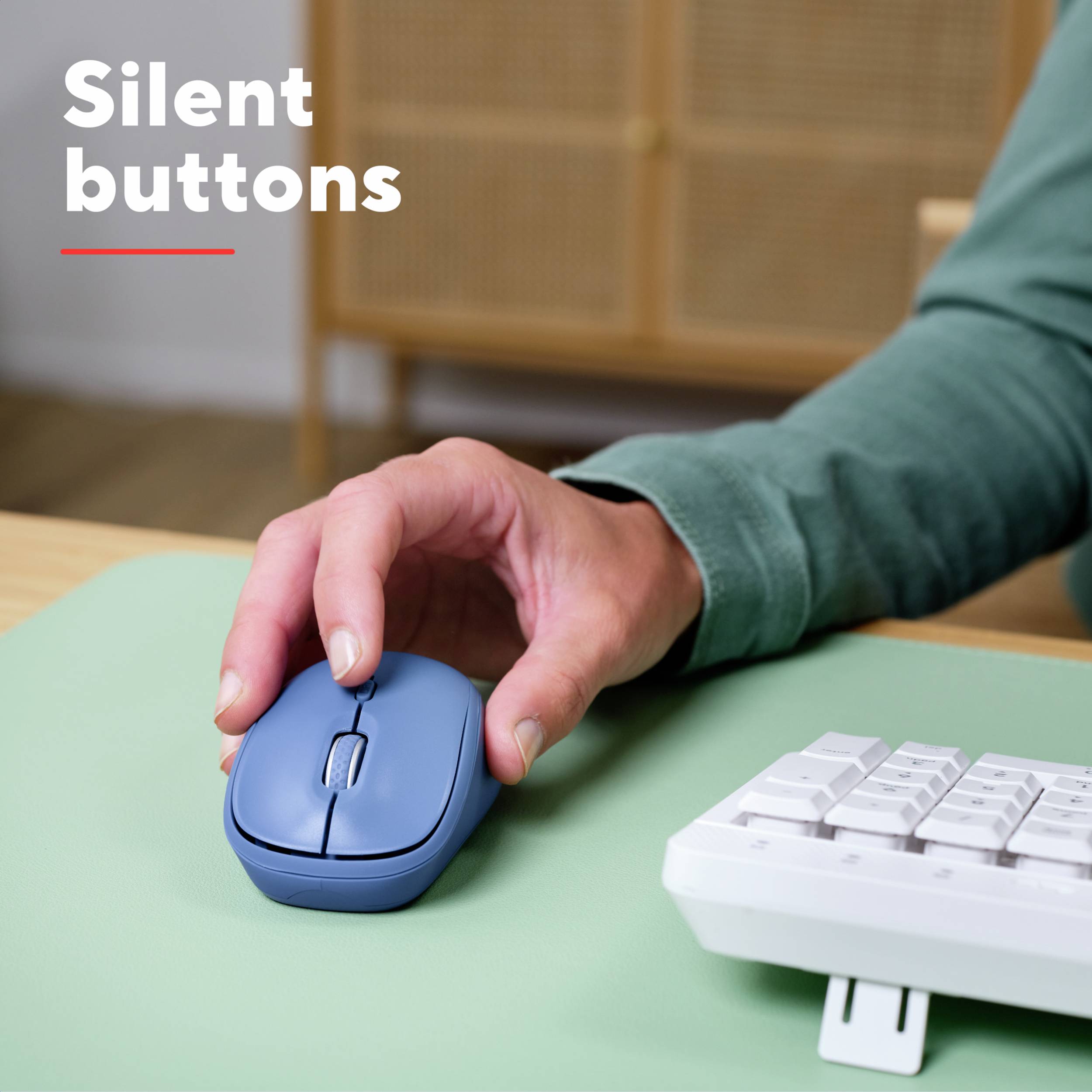 Une personne utilise une souris avec des touches silencieuses sur un bureau, à côté d'un clavier. Texte : 'Touches silencieuses'.