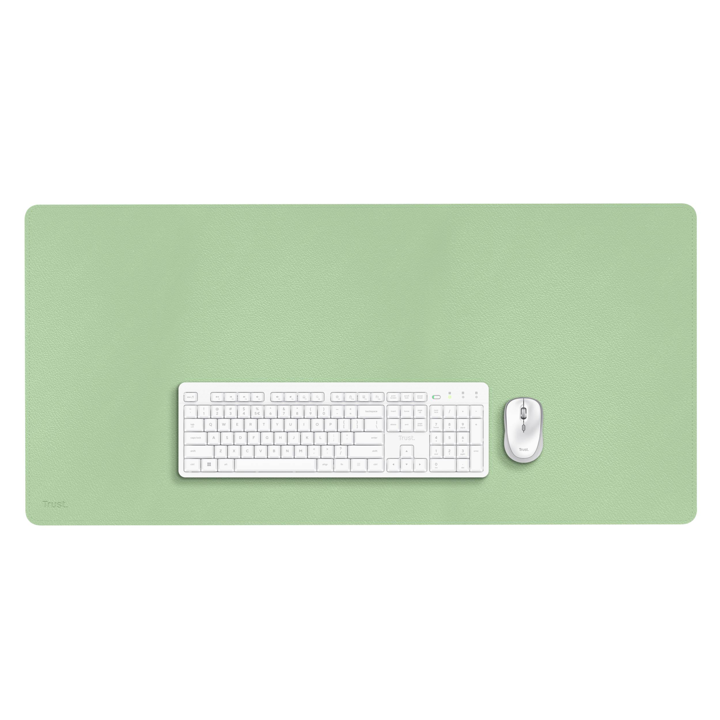 Un clavier et une souris blancs sont posés sur un grand tapis de bureau vert.
