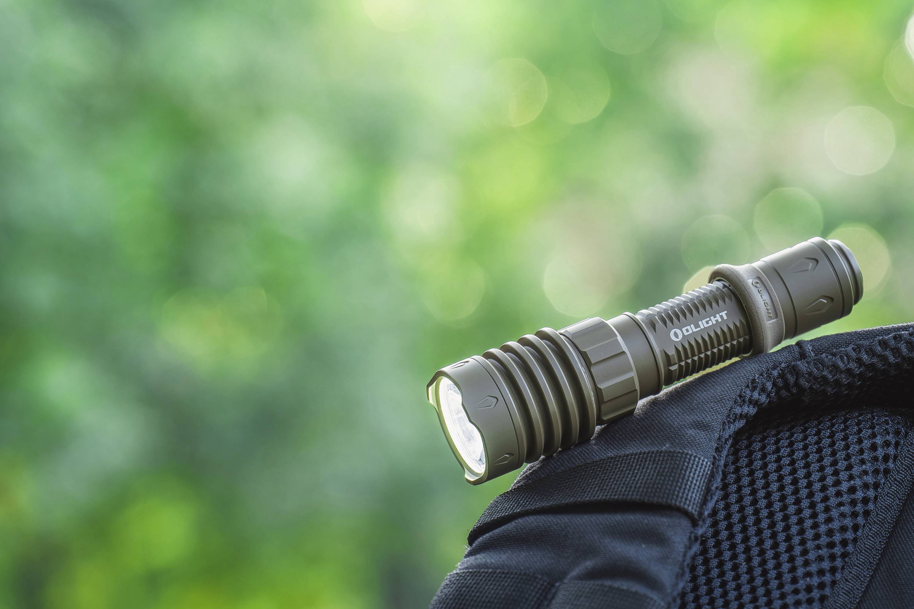 Sac avec lampe de poche intégrée, arrière-plan vert flou.