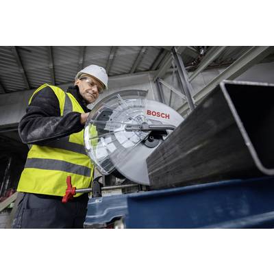 Une personne en tenue de travail et portant un casque utilise une scie Bosch dans un environnement industriel.