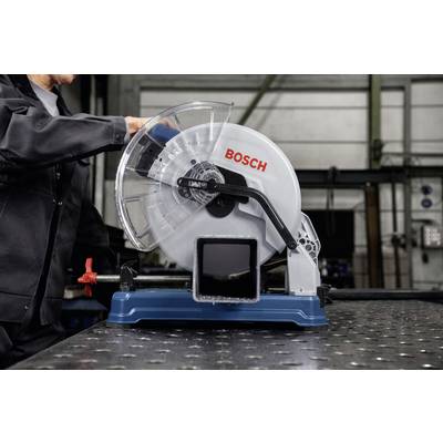 Une personne utilise une scie à métaux Bosch sur une table dans un environnement d'atelier.