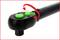 Une clé dynamométrique noire avec des boutons verts montre comment tourner le bouton de réglage avec une flèche rouge pour ajuster la tension.